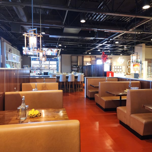 Interior of Garnish Restaurants, an Indian restaurant, with empty booths, tables, and a bar area.